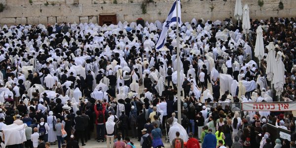 a large group of people standing in front of a stone wall