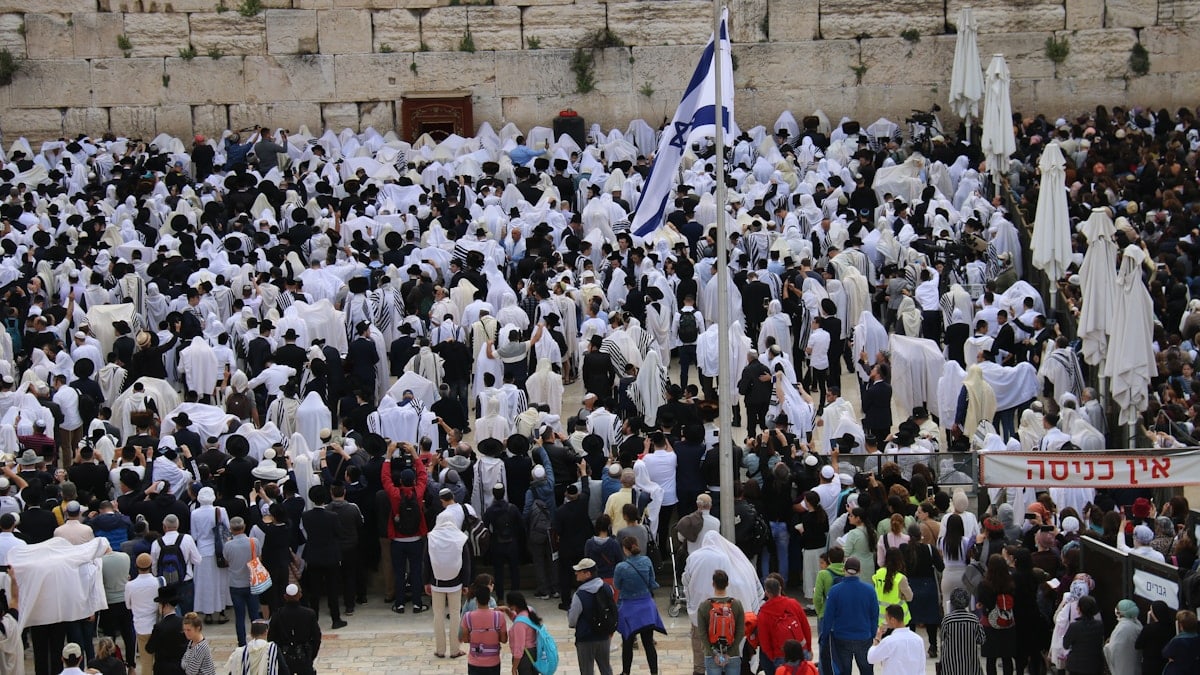 a large group of people standing in front of a stone wall